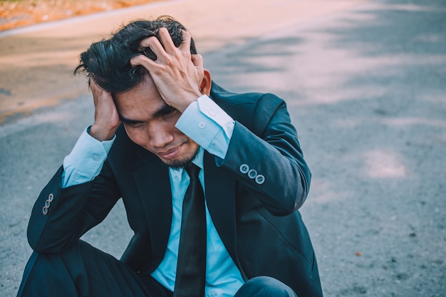 El hombre de negocios falla en el trabajo y los negocios, la gente de negocios se siente estresante y con dolor de cabeza