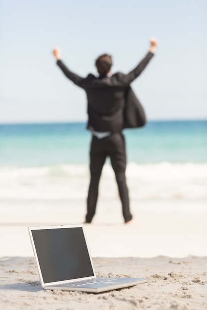 Hombre de negocios feliz animando frente al mar