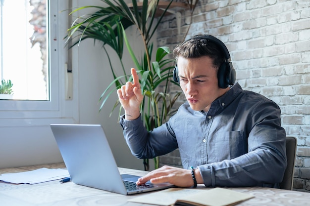 Hombre de negocios feliz con auriculares cantando una canción en el lugar de trabajo empleado divertido o freelancer usando la