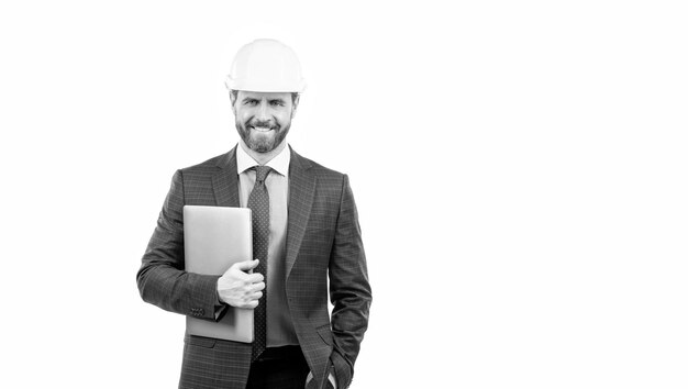 Hombre de negocios feliz en casco de seguridad sostenga la computadora portátil aislada en el espacio de copia en blanco negocio de seguridad