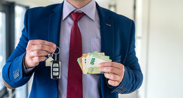 Hombre de negocios feliz compró un apartamento y un coche y tiene las llaves