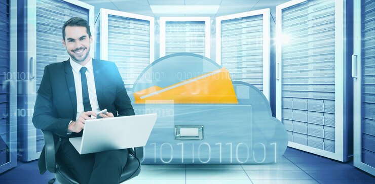 Foto hombre de negocios feliz con una computadora portátil usando un teléfono inteligente contra una imagen compuesta del cajón de la computación en la nube