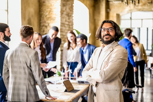 Hombre de negocios feliz y confiado sonriendo y orgulloso de su grupo de trabajo en equipo discutiendo sobre estrategia financiera e intereses económicos y ambientales de energía renovable