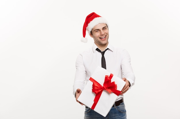 Hombre de negocios feliz guapo dando regalo con sombrero de santa posando