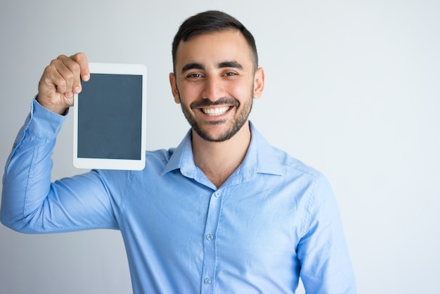 Hombre de negocios feliz guapo mostrando tableta