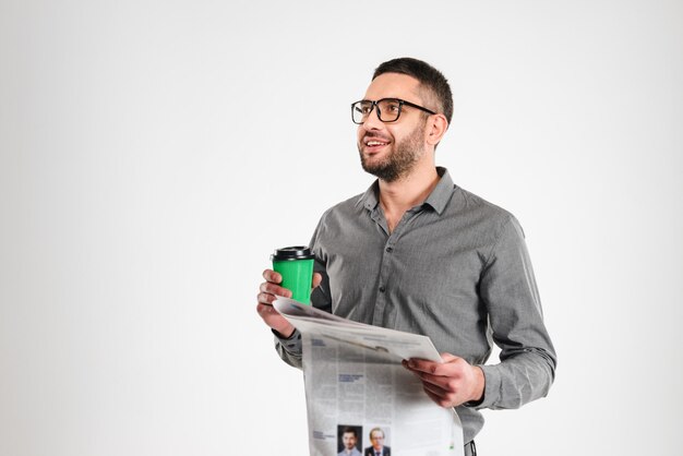 Hombre de negocios feliz leyendo el periódico tomando café