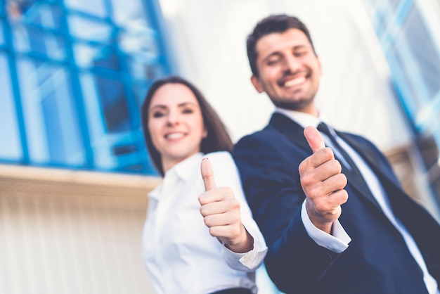 El hombre de negocios feliz y la mujer pulgar hacia arriba