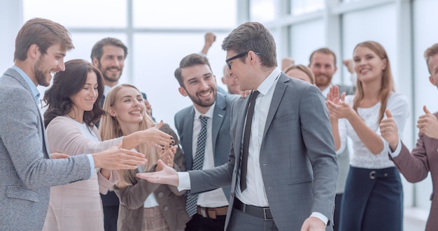 Hombre de negocios feliz de pie entre el concepto de éxito de sus colegas