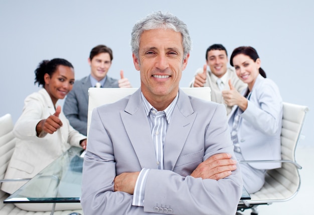 Foto hombre de negocios feliz que lleva a su equipo feliz con los pulgares para arriba