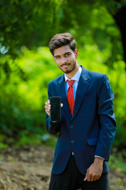 Hombre de negocios feliz con smartphone al aire libre