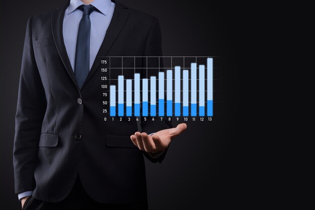 El hombre de negocios con gráficos holográficos y estadísticas del mercado de valores obtiene beneficios. Concepto de planificación del crecimiento y estrategia empresarial. Visualización de pantalla digital de buena forma económica.