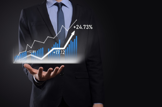 Hombre de negocios con gráficos holográficos y estadísticas del mercado de valores obtiene beneficios