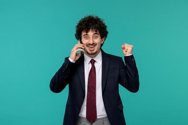 Hombre de negocios guapo chico joven lindo en traje negro y corbata roja hablando por teléfono