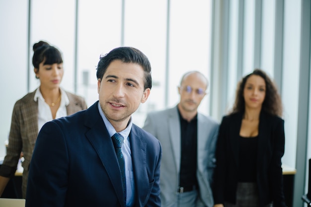 Hombre de negocios guapo confiado frente a su equipo