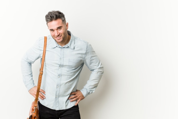 Hombre de negocios guapo joven confía en mantener las manos en las caderas.