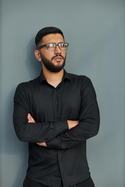 Hombre de negocios guapo joven vestido con camisa de mezclilla casual con reloj inteligente en la muñeca