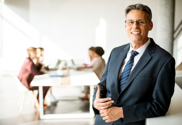 Hombre de negocios guapo seguro de pie en la oficina