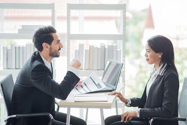 El hombre de negocios habla con una mujer de negocios o un socio africano sobre las ganancias de la empresa