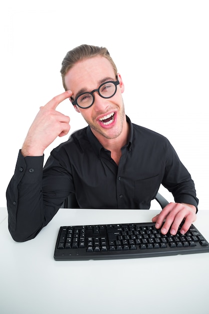 Hombre de negocios haciendo una cara y escribiendo en el teclado sobre fondo blanco