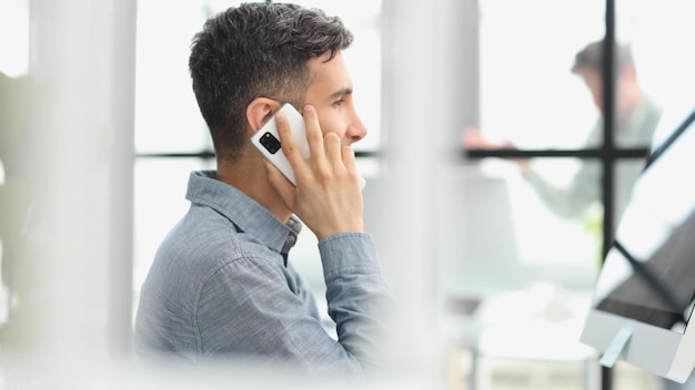 Un hombre de negocios haciendo compras por teléfono en una oficina.