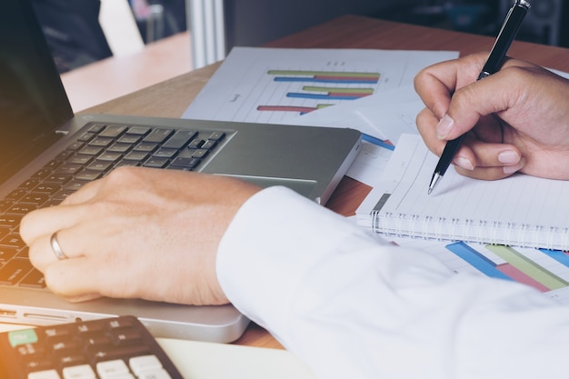 Hombre de negocios haciendo notas en el papel en su oficina