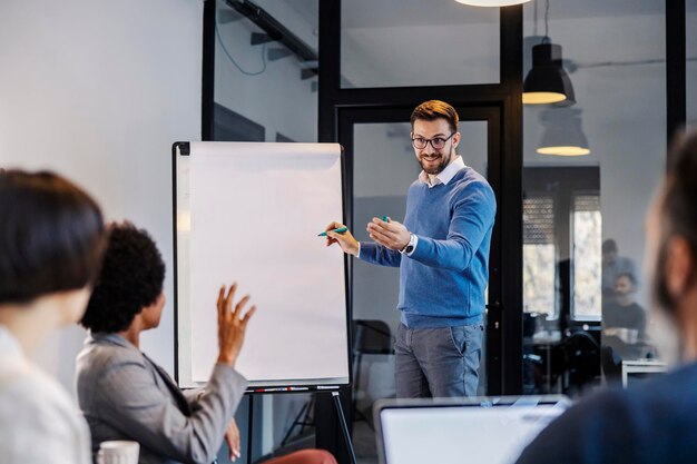 Foto un hombre de negocios está haciendo una tormenta de ideas y escribiendo en una tabla blanca ideas con su equipo interracial