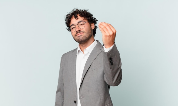 ¡Hombre de negocios hispano haciendo capice o gesto de dinero, diciéndole que pague sus deudas!