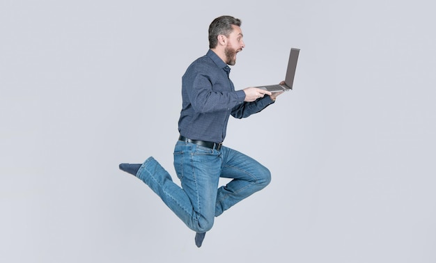 Hombre de negocios hombre de salto enérgico sorprendido corriendo mientras trabaja en línea en la computadora portátil, apúrate para ir de compras, negocios.