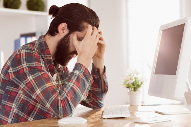 Foto hombre de negocios inconformista tensionado en su escritorio