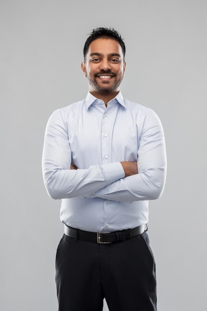 hombre de negocios indio en camisa sobre fondo gris