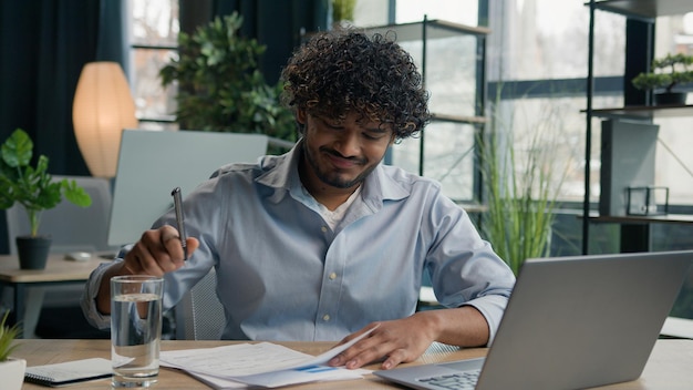 Hombre de negocios indio frustrado hombre de negocios árabe en el escritorio trabajo difícil resolver el problema con el papeleo documentos pérdida de finanzas problemas presupuestarios sentir estrés decepcionado emociones negativas