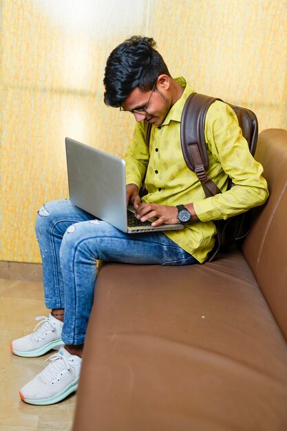 Hombre de negocios indio sonriente usando computadora portátil