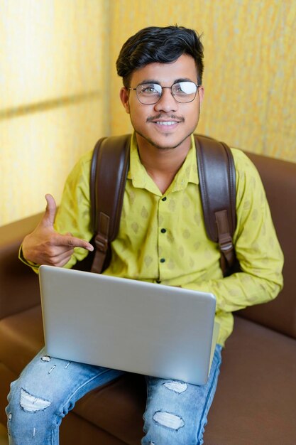 Hombre de negocios indio sonriente usando computadora portátil
