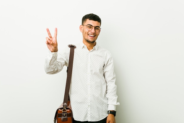 Foto hombre de negocios informal joven alegre y despreocupado mostrando un símbolo de paz con los dedos