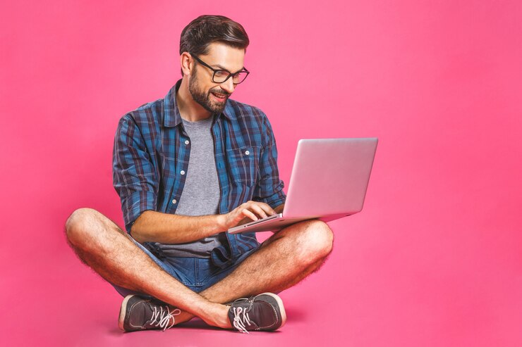 Foto hombre de negocios informal relajado trabajando y navegando por internet en la computadora portátil. independiente sentado y escribiendo en el teclado del portátil en la oficina en casa