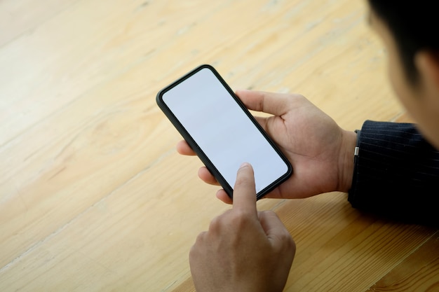 Hombre de negocios irreconocible utilizando un teléfono móvil.