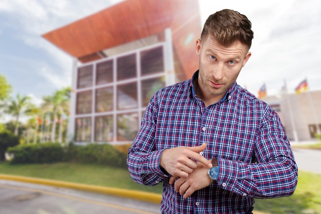 Hombre de negocios joven asombroso hermoso que señala en el reloj