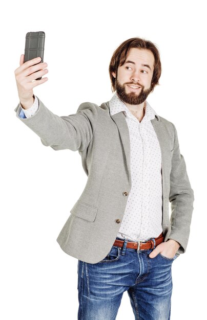 Hombre de negocios joven barbudo tomando selfie retrato sonriente aislado sobre fondo blanco studio