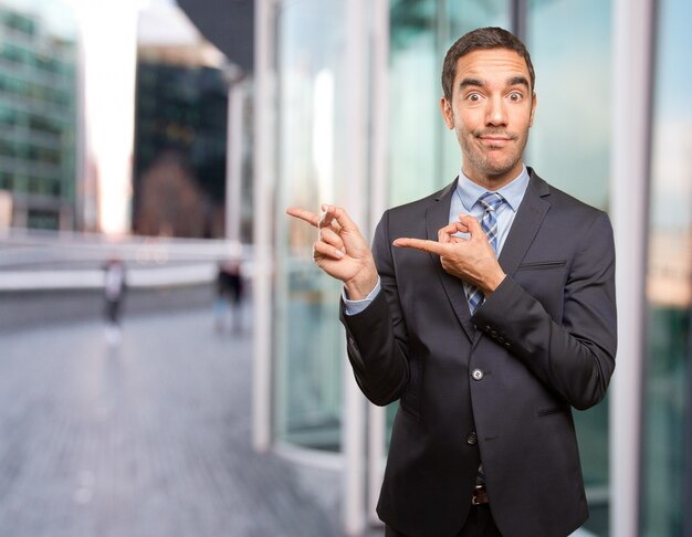 Hombre de negocios joven feliz apuntando