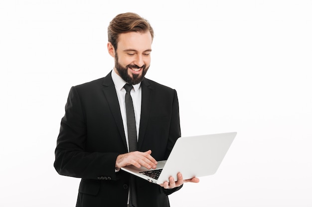 Hombre de negocios joven feliz que usa la computadora portátil.