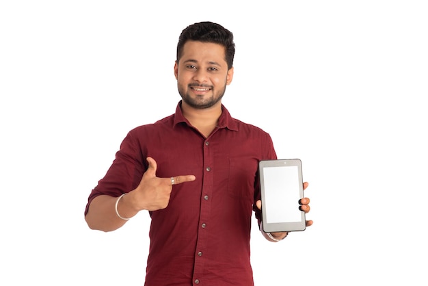 Hombre de negocios joven y guapo que muestra una pantalla en blanco de un teléfono inteligente o teléfono móvil o tableta con fondo blanco