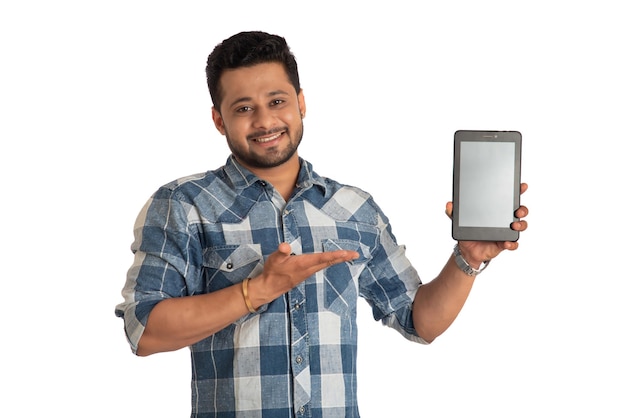 Hombre de negocios joven y guapo que muestra una pantalla en blanco de un teléfono inteligente o teléfono móvil o tableta con fondo blanco