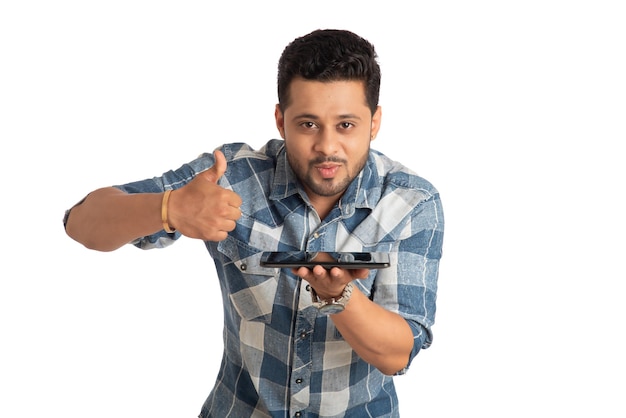 Hombre de negocios joven y guapo que muestra una pantalla en blanco de un teléfono inteligente o teléfono móvil o tableta con fondo blanco