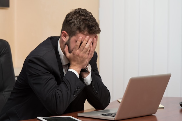 Foto hombre de negocios joven con problemas y estrés en la oficina