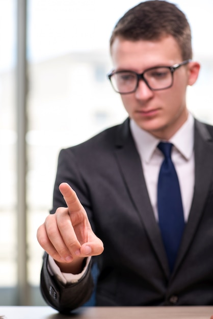 Hombre de negocios joven que presiona los botones en concepto del negocio