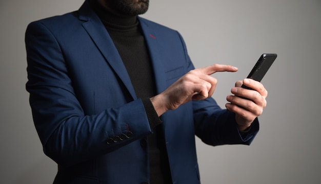 Hombre de negocios joven que sostiene el teléfono inteligente