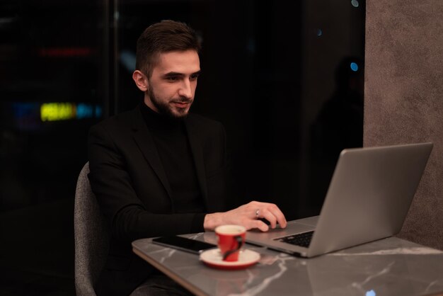 Hombre de negocios joven que trabaja en una computadora portátil en su oficina durante la noche
