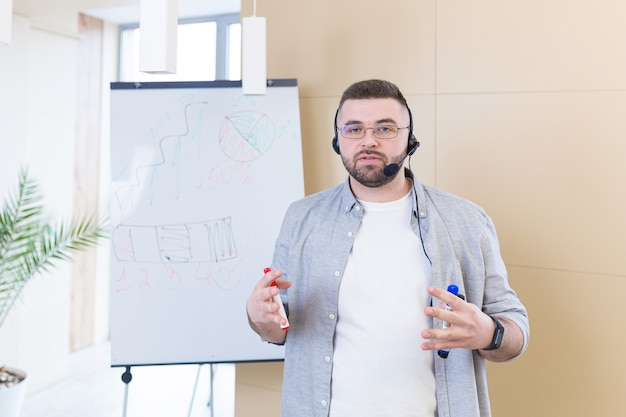 Hombre de negocios joven en ropa casual con un auricular presentación de reunión en línea