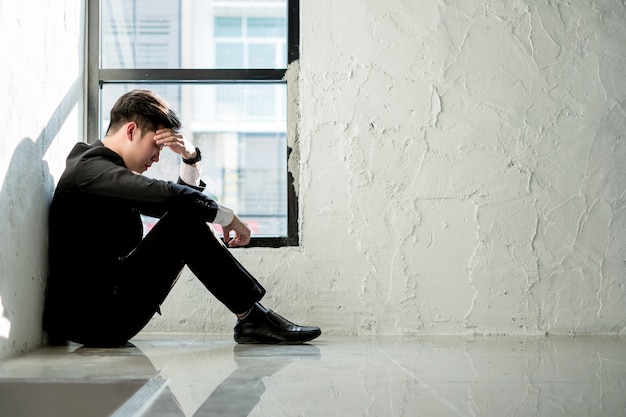 hombre de negocios joven sentado en la oficina sentirse cansado y estresado, concepto de negocio