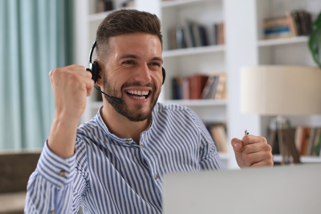 Hombre de negocios joven sonriente con videollamada en la oficina.